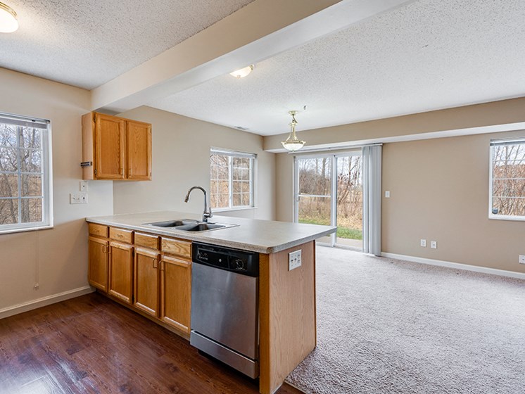 kitchen island overlooking empty, carpeted living room